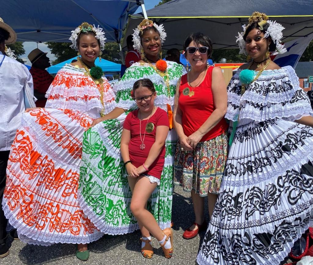 Columbus Rotarian Julie Bond and Julie and Ian's granddaughter with Panamanian dancers at the festival