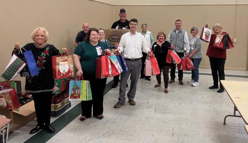 Rotarians, Womans Club and Manchester Kiwanis Club in action showing off Christmas bags for Seniors 2024.jpg