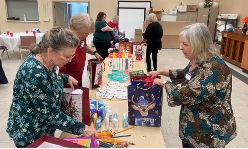 Rotarians and Woman's Club in action putting together Christmas bags for Seniors 2024.jpg