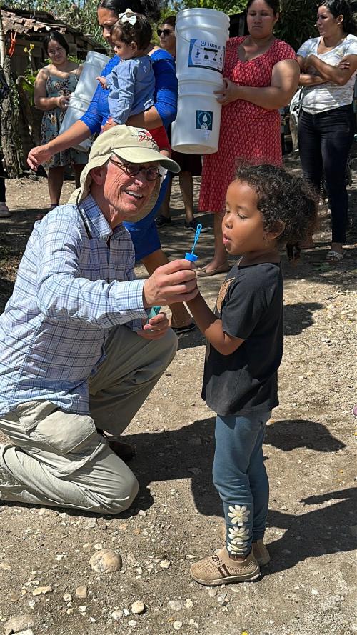 Richard with child during delivering water filters.JPG